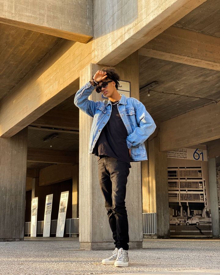 Man in a washed denim jacket and black tee